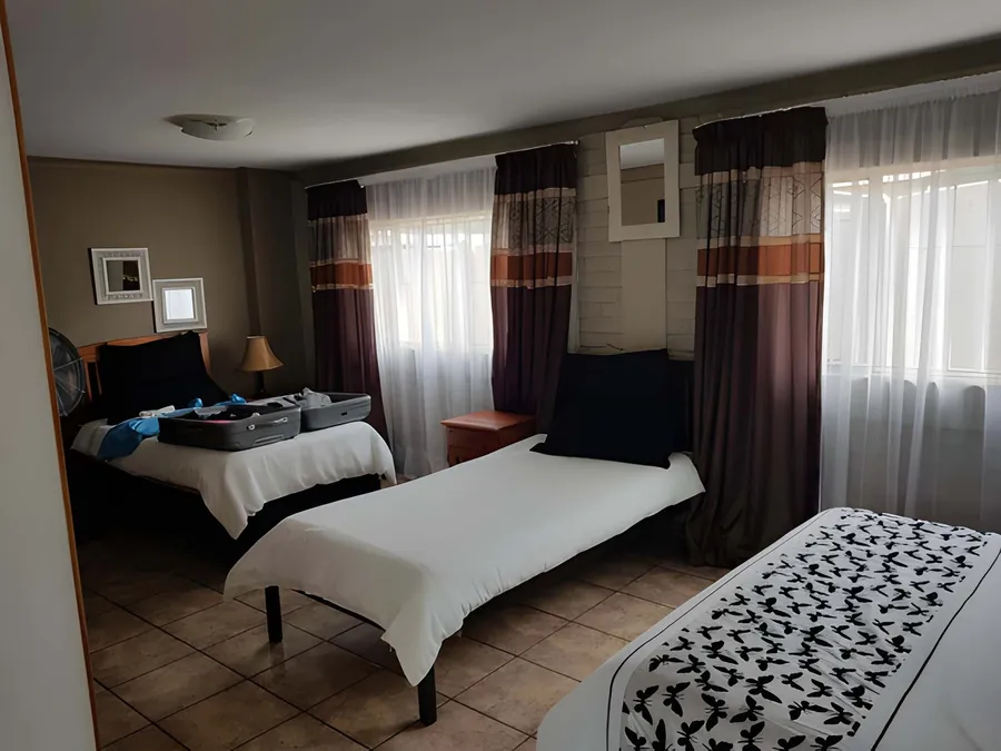 A family room with two double beds and space for luggage